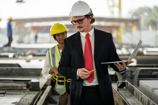 Un supervisor de obra analiza los planos del proyecto en una computadora ejemplo de ¿Qué hace un supervisor de obra?