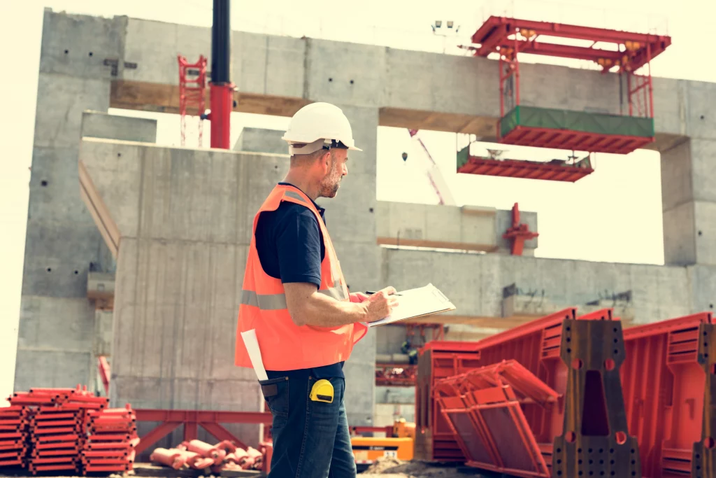 Supervisor revisa documentos en una obra en construcción. Es clave para la seguridad industrial y prevención de riesgos