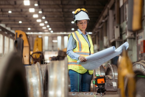 Ingeniera supervisando una obra industrial para demostrar para qué sirve la gerencia de proyectos en el control real.